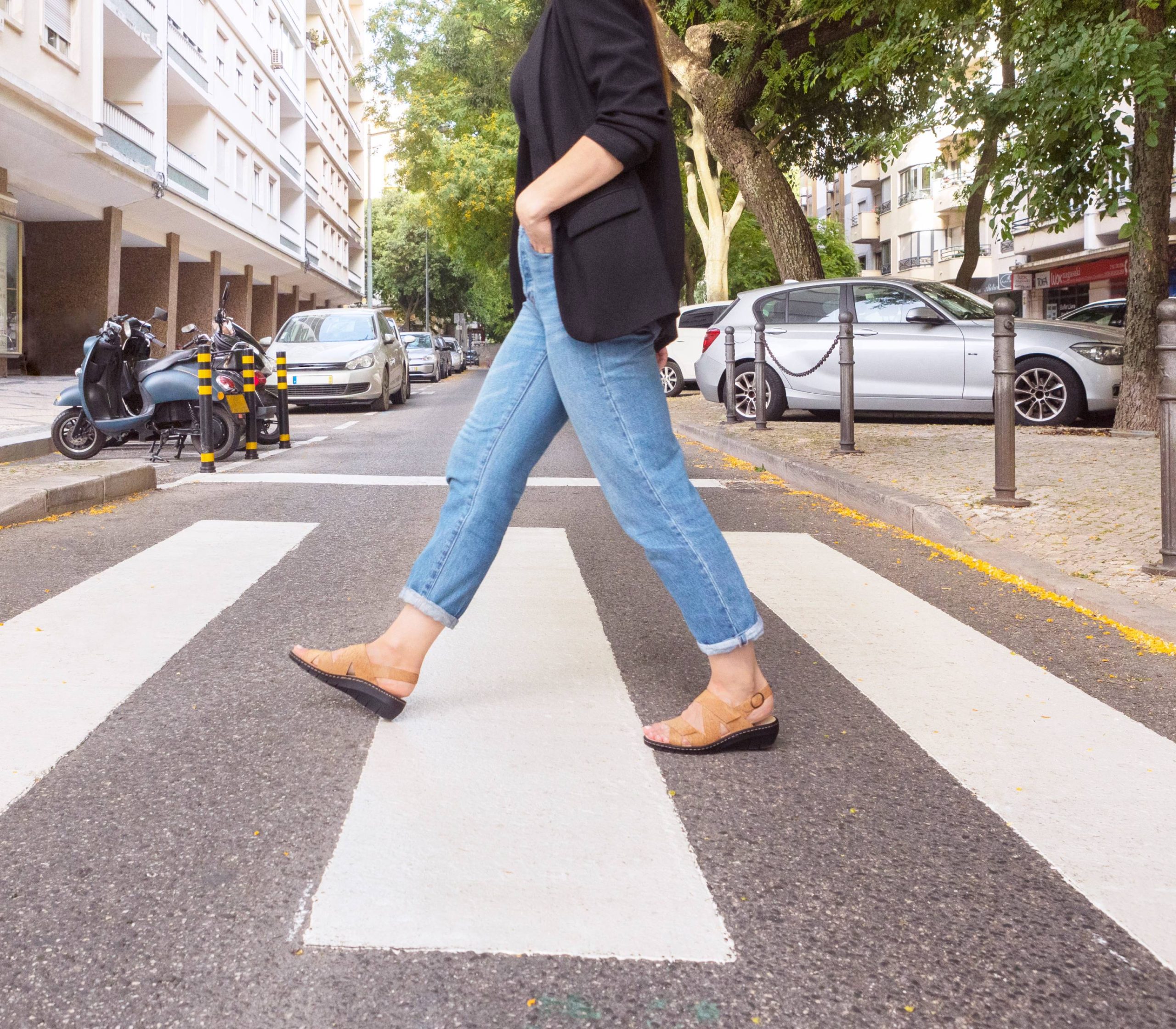 Portina leather sandals worn on a city crosswalk